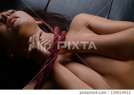 Woman in lingerie poses gracefully with ropes, showcasing beauty and elegance Woman in lingerie poses gracefully with ropes, showcasing beauty and elegance 130014012