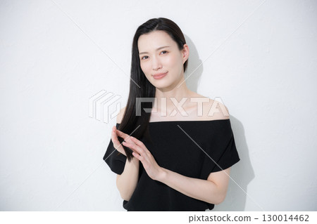 A woman doing hair care for the ends of her hair. Image of treatment and split ends. 130014462