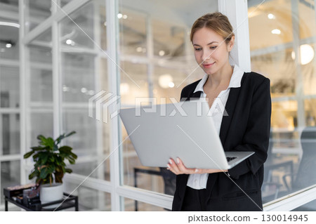 Good-looking female manager in the office looking confident 130014945