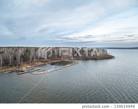 Colorful autumn forest with trees on the shore of a blue lake - top aerial view. Colorful autumn forest with trees on the shore of a blue lake - top aerial view. 130014949