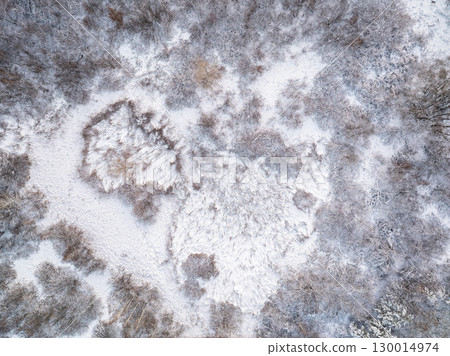 Aerial view of a winter pine forest. Top view of snow-covered pine trees. Beautiful winter forest landscape. Aerial view of a winter pine forest. Top view of snow-covered pine trees. Beautiful winter forest landscape. 130014974