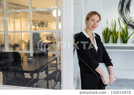 Good-looking female manager in the office looking confident Good-looking female manager in the office looking confident 130014978