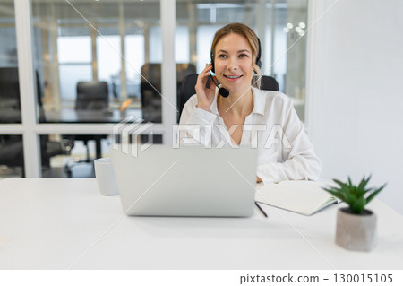 Young confident business woman having a call and looking involved 130015105