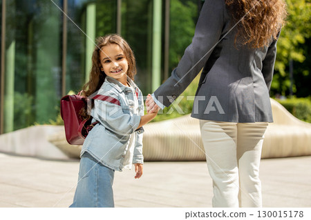 Brunette woman with young schoolgirl standing together 130015178