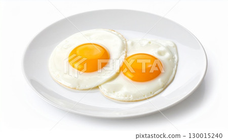 Two fried eggs resting on a white plate, embodying a simple breakfast 130015240