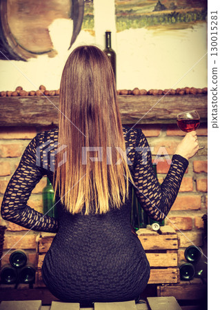 Woman tasting wine in rural cottage interior 130015281