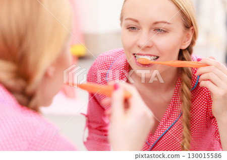 Woman brushing cleaning teeth in bathroom 130015586