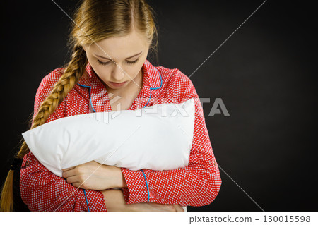 Sad depressed girl in bed gripping pillow Sad depressed girl in bed gripping pillow 130015598