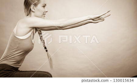 Woman training at home doing sit ups squats 130015634