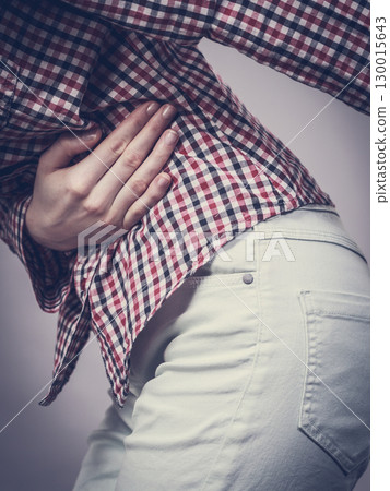 Woman feeling stomach cramps holding her belly 130015643
