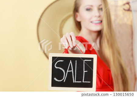 Woman in shop picking clothes, sale concept 130015650