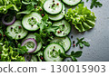 Fresh green salad with cucumber, arugula, red onion and spices on grey background 130015903