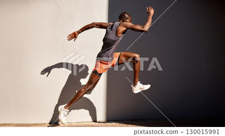 Athletic man leaping in action against a gray background 130015991