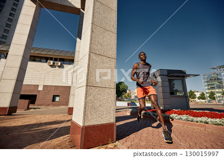 Man jogging outdoors in an urban area on a sunny day Man jogging outdoors in an urban area on a sunny day 130015997