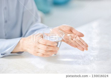 Hands of a middle-aged woman taking medicine Hands of a middle-aged woman taking medicine 130016024