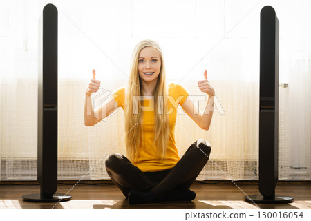Woman next to speakers at home Woman next to speakers at home 130016054
