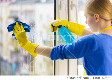 Woman cleaning window at home 130016068