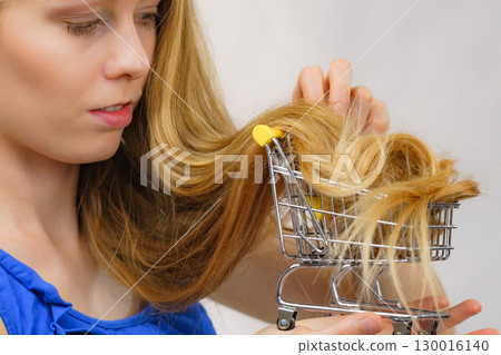Girl with her long hair in shopping cart 130016140