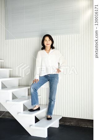 Middle-aged female beauty posing on the stairs 130016171