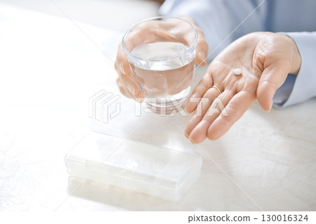 一位中年婦女吃藥的手 130016324