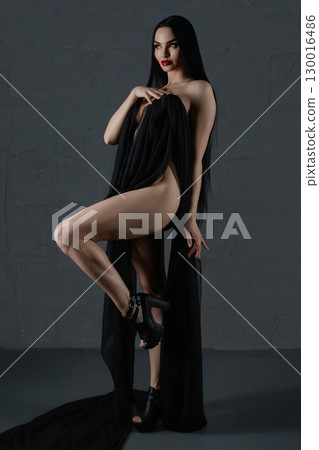 Elegant woman showcasing beauty in lingerie with flowing fabric accents 130016486