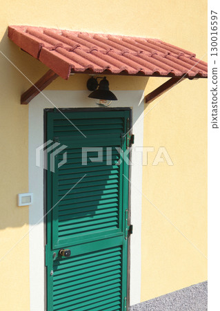 Traditional green doors and windows of Liguria. Tiled canopy. Traditional buildings of Italy. Copy space for design.  130016597