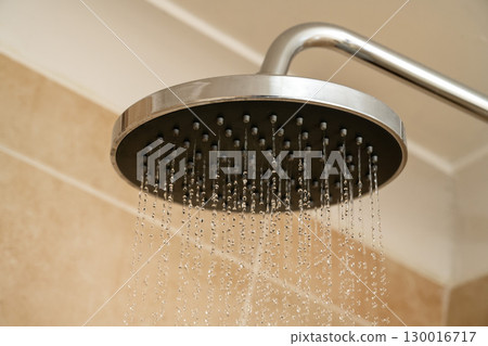 Chrome shower head with water droplets. Increasing water bills. 130016717