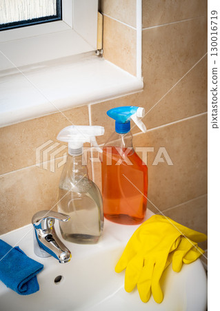 Spray detergents, cleaning bathroom basin and water tap, yellow gloves and fibber cloth 130016719