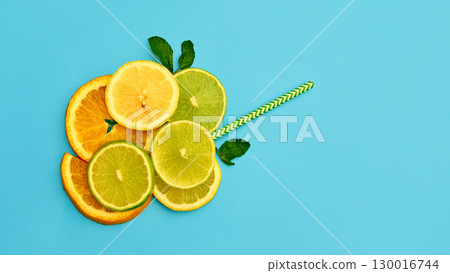 Citrus slices with green straw on blue background Citrus slices with green straw on blue background 130016744