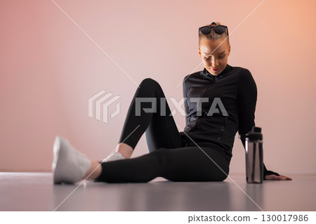 Woman in activewear resting with water 130017986