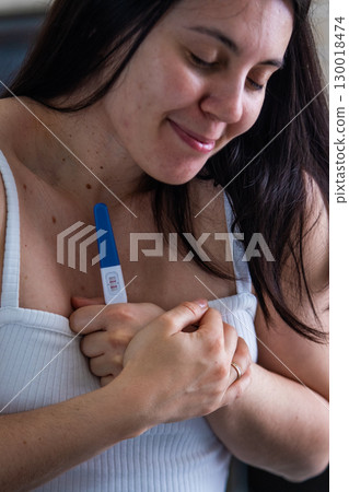 Surprised Woman with Positive Pregnancy Test Surprised Woman with Positive Pregnancy Test 130018474