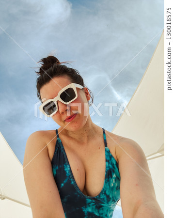 Woman in Sunglasses and Swimsuit Under Blue Sky 130018575