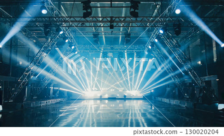 Illuminated concert stage with vibrant blue lighting and symmetrical structure Illuminated concert stage with vibrant blue lighting and symmetrical structure 130020204