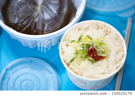 Kalguksu in a plastic box on a blue background. Food delivery 130020279