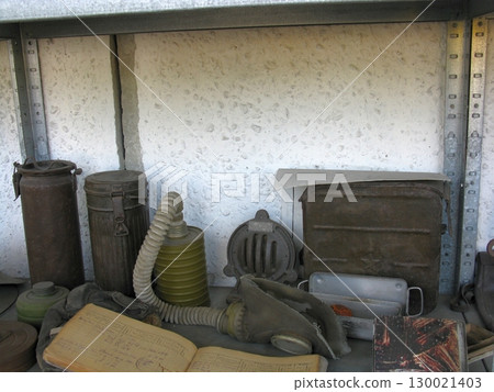 Rustic Shelf Displaying Vintage Gas Masks, Containers, and Military Documents Rustic Shelf Displaying Vintage Gas Masks, Containers, and Military Documents 130021403