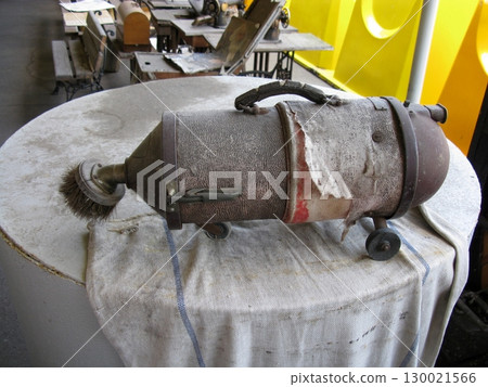 Vintage Vacuum Cleaner on a Round Table with a Worn Fabric Cover Vintage Vacuum Cleaner on a Round Table with a Worn Fabric Cover 130021566