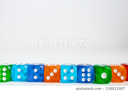 Colorful assortment of dice arranged in a row on white background Colorful assortment of dice arranged in a row on white background 130021907