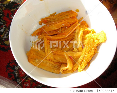 White Bowl Filled with Candied Fruit Strips on a Patterned Surface in Warm Light White Bowl Filled with Candied Fruit Strips on a Patterned Surface in Warm Light 130022257
