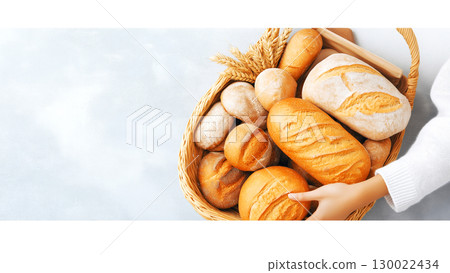 Assortment of freshly baked bread in wicker basket 130022434