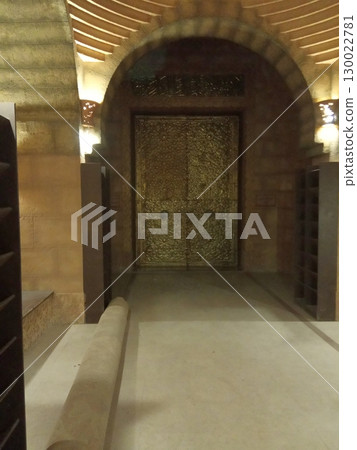 Golden Ornate Doorway Under an Arched Stone Entrance with Warm Lighting Golden Ornate Doorway Under an Arched Stone Entrance with Warm Lighting 130022781