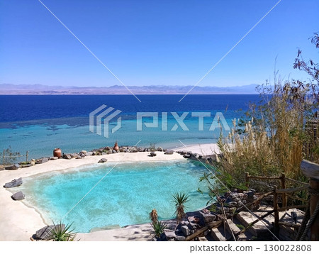 Beachside Pool with Turquoise Water Near the Ocean and Distant Mountains Beachside Pool with Turquoise Water Near the Ocean and Distant Mountains 130022808