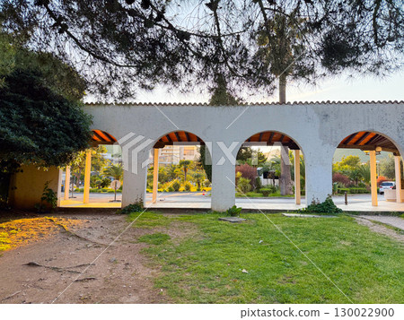 Arched passage with sunlight shining through. Architectural symmetry reflecting culture and timeless urban design. Arched passage with sunlight shining through. Architectural symmetry reflecting culture and timeless urban design. 130022900