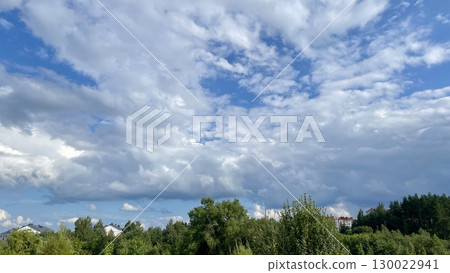 Cloudy Sky Above Forest and Buildings 130022941