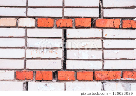 Textured texture of white and red brick.Cracked old brick wall. Brick close-up. 130023089