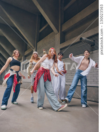 Dance crew posing in stylish urban clothes during expressive group choreography Dance crew posing in stylish urban clothes during expressive group choreography 130023563