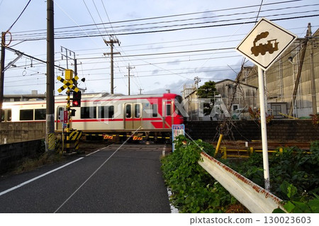 一列名鐵列車正通過鐵路道口，道口處有警示標誌 130023603