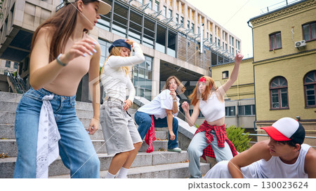 Street dance crew in coordinated motion showing unity and urban creative spirit 130023624