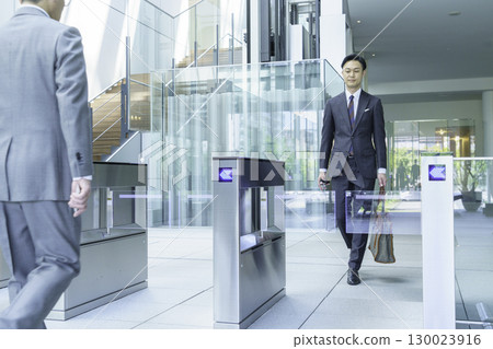 一位西裝革履的商人正從辦公室入口走過。圖片由Sky Perfect Tokyo Media Center提供。 一位西裝革履的商人正從辦公室入口走過。圖片由Sky Perfect Tokyo Media Center提供。 130023916
