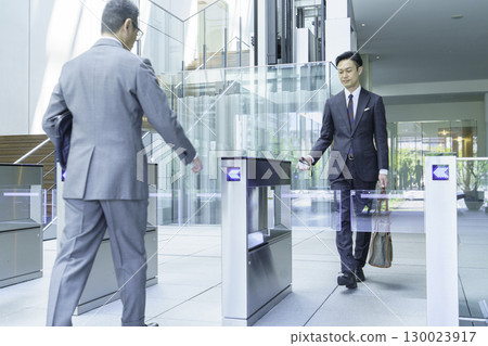 一位西裝革履的商人正從辦公室入口走過。圖片由Sky Perfect Tokyo Media Center提供。 一位西裝革履的商人正從辦公室入口走過。圖片由Sky Perfect Tokyo Media Center提供。 130023917