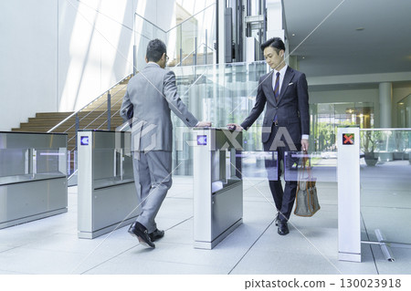 A businessman in a suit walking through the office entrance. Photo courtesy of Sky Perfect Tokyo Media Center. 130023918